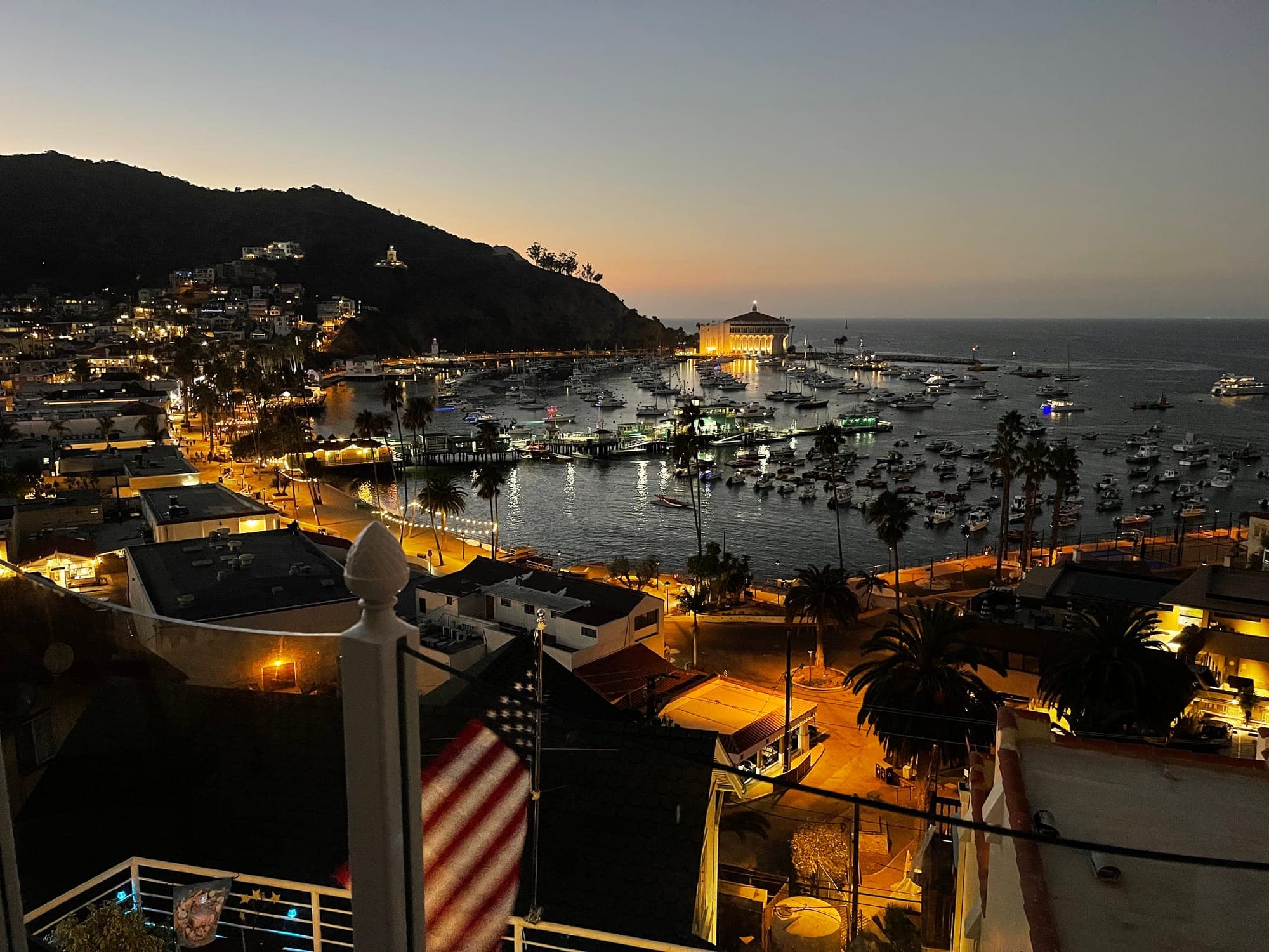 Avalon Harbor and the lit Casino at dusk